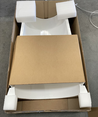Overhead of a custom cardboard shipping box with foam insert protecting oddly shaped item in box.